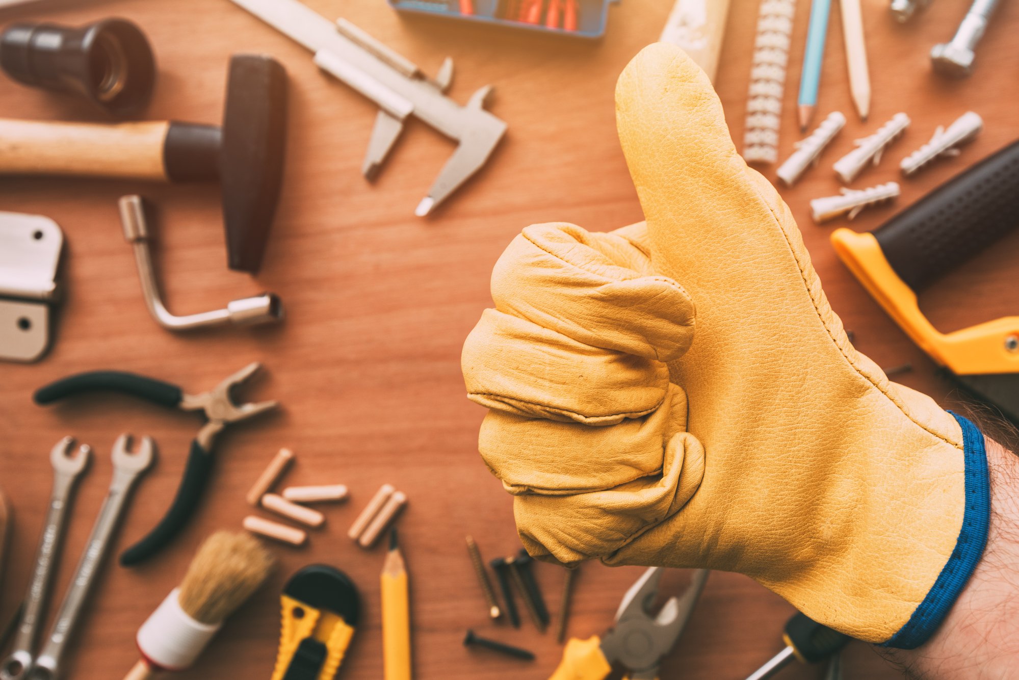 Maintenance handyman gesturing thumb up approval hand sign over the work desk with DIY tools, top view